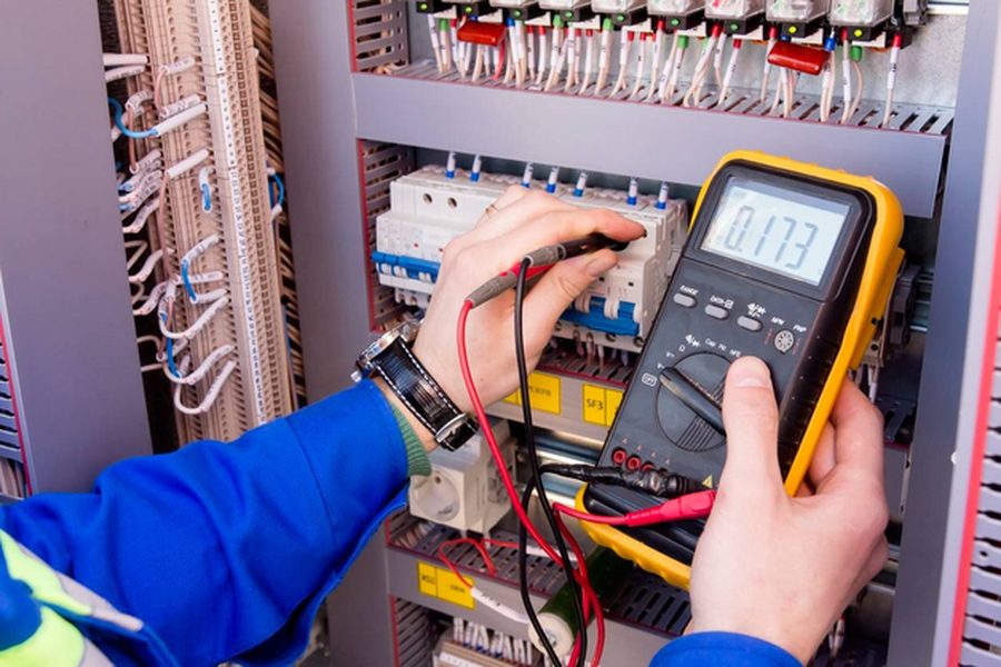 Electricista realizando mediciones en un tablero eléctrico industrial